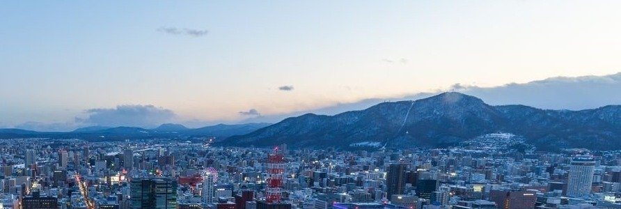 雪の積もった冬の札幌の街並みと山並み